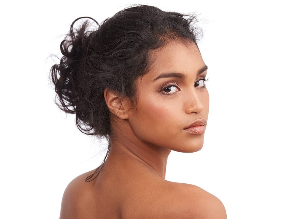 woman look over her shoulder with her hair tied up