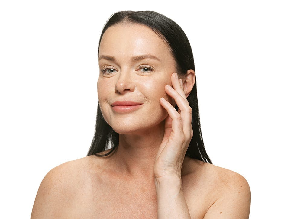 woman grinning and touching her cheekbone