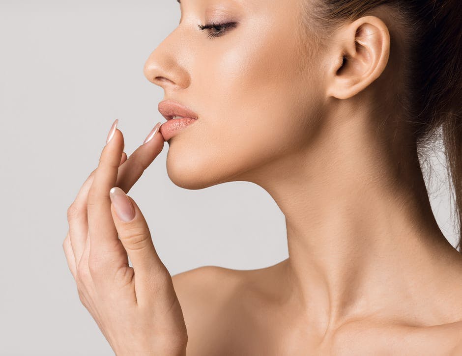 side profile of woman touching bottom lip with her finger