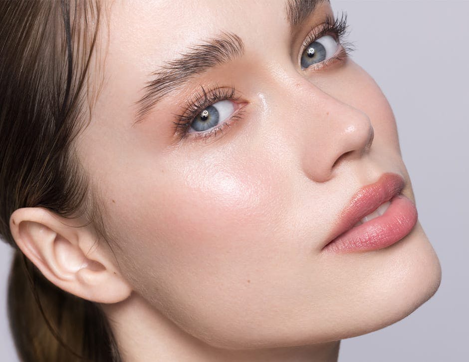 close up of woman with blue eyes with light pink lipstick