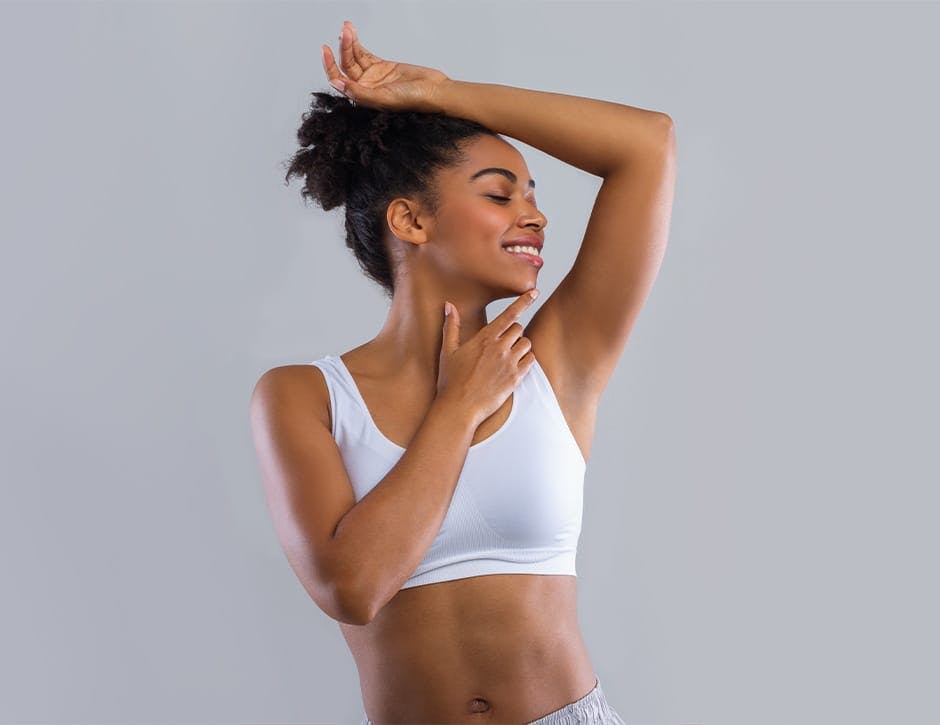 woman lifting her arm above her head while touching her chin with her finger