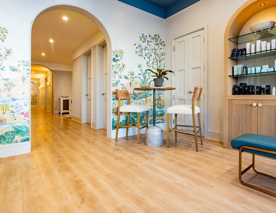 room with skincare wall, tables and chairs and decorated wall art