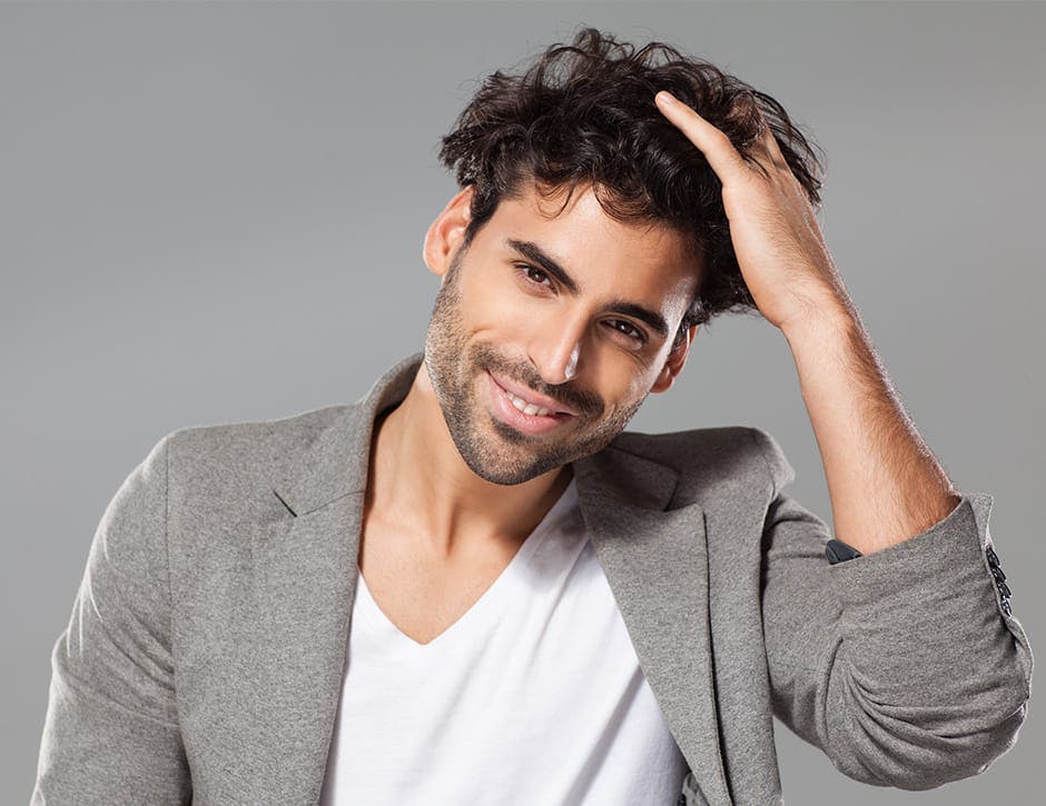 man with fluffy hair in gray jacket
