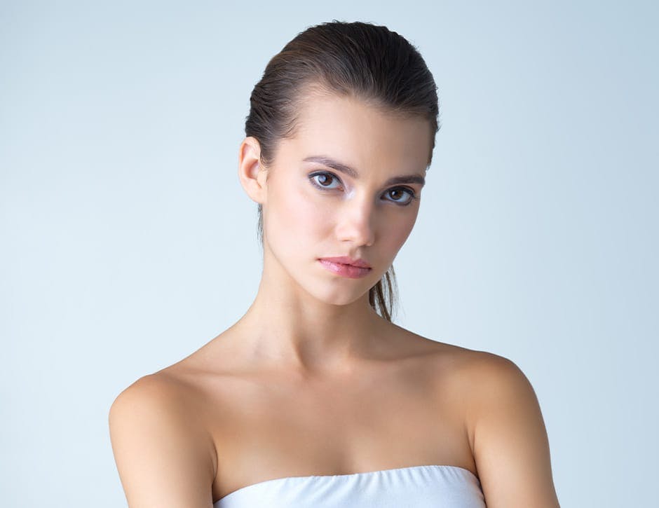 woman tilting her head down and hair tied back