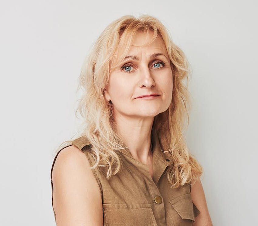 woman with blonde curly hair looking forward