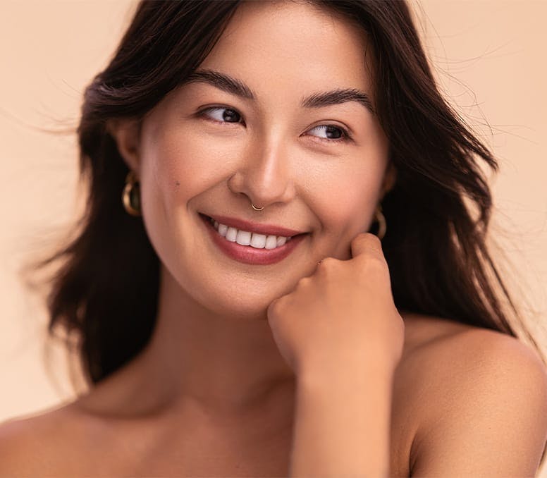 woman smiling with hand in fist on her jaw