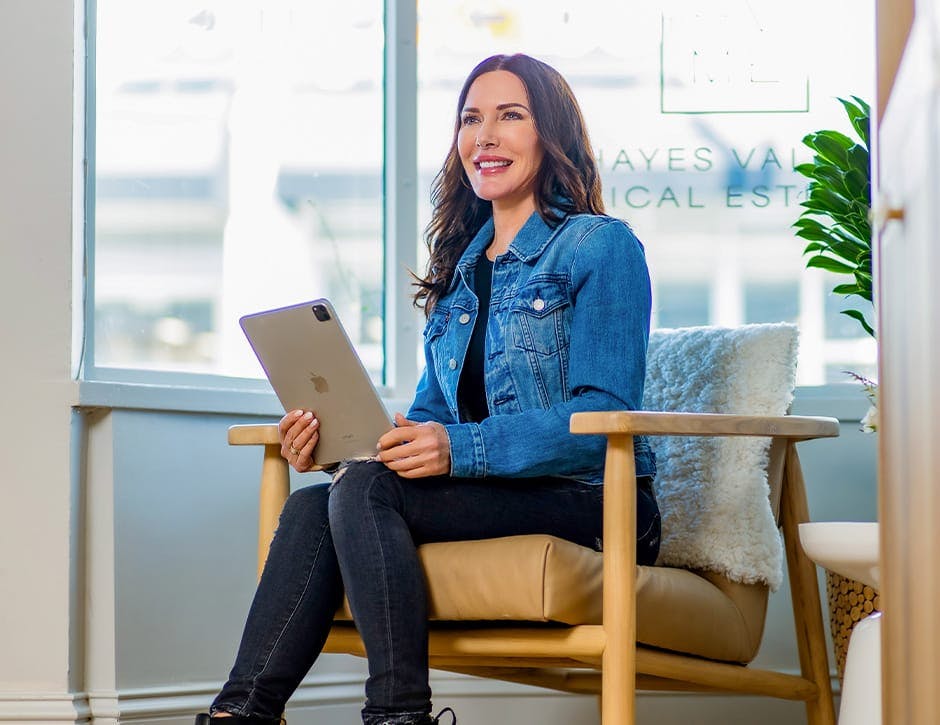 woman sitting in seat with ipad in hand