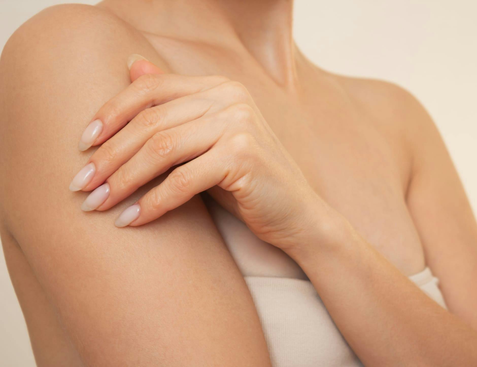 close up of woman rubbing her arm
