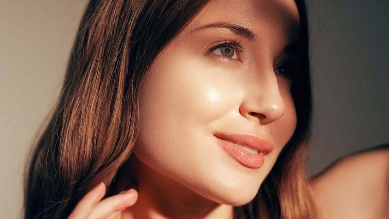 Woman smiling away from camera as sun hits cheek