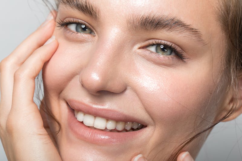 Young woman with beautiful skin is smiling at the camera