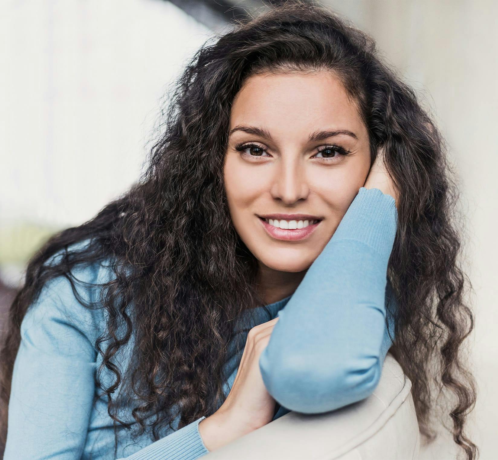 Smiling woman resting head in her arm