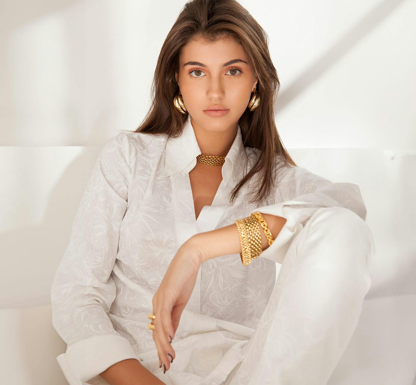 Woman in white blouse with gold jewelry