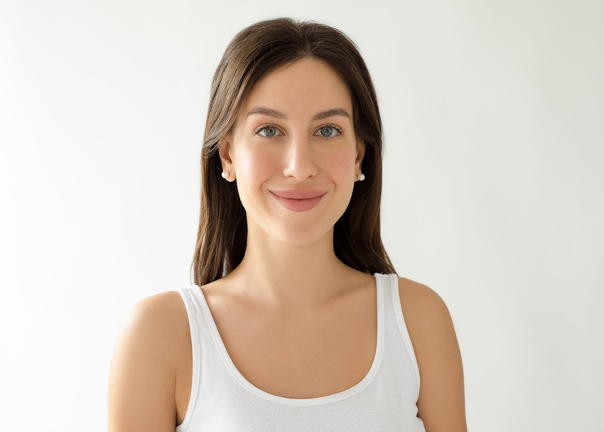 woman with long brown hair wearing a white tank top