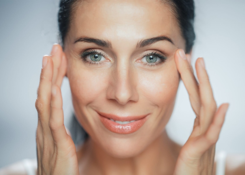 Woman running fingers over eye wrinkles