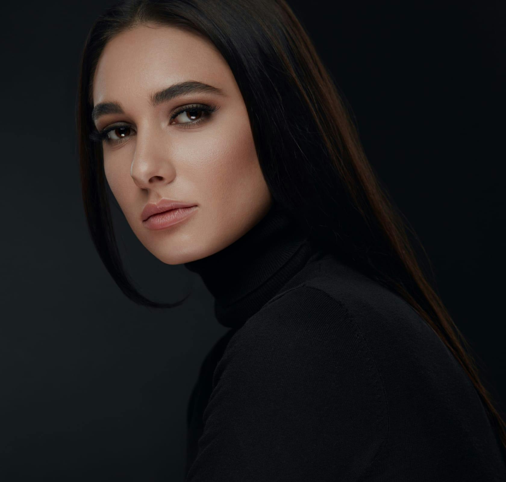 woman with long straight dark hair wearing a black turtleneck