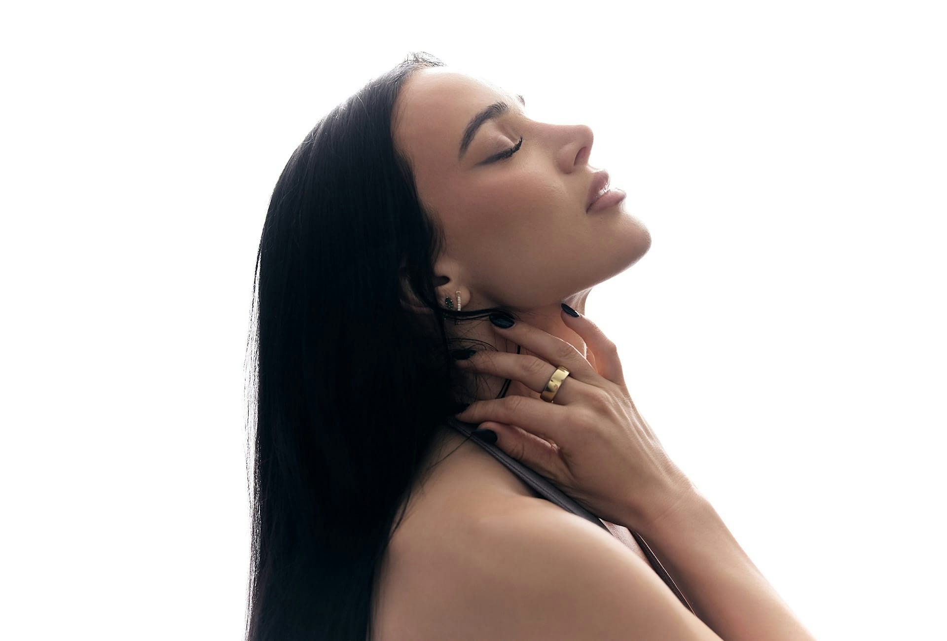 woman holding her neck, leaning her head back with her eyes closed