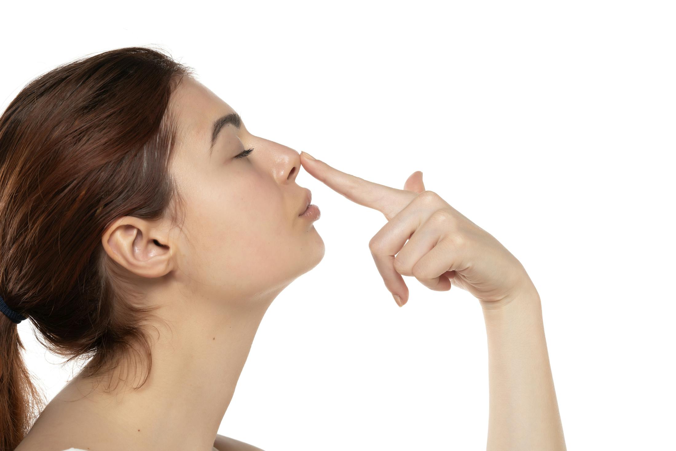 A woman touching the tip of her nose