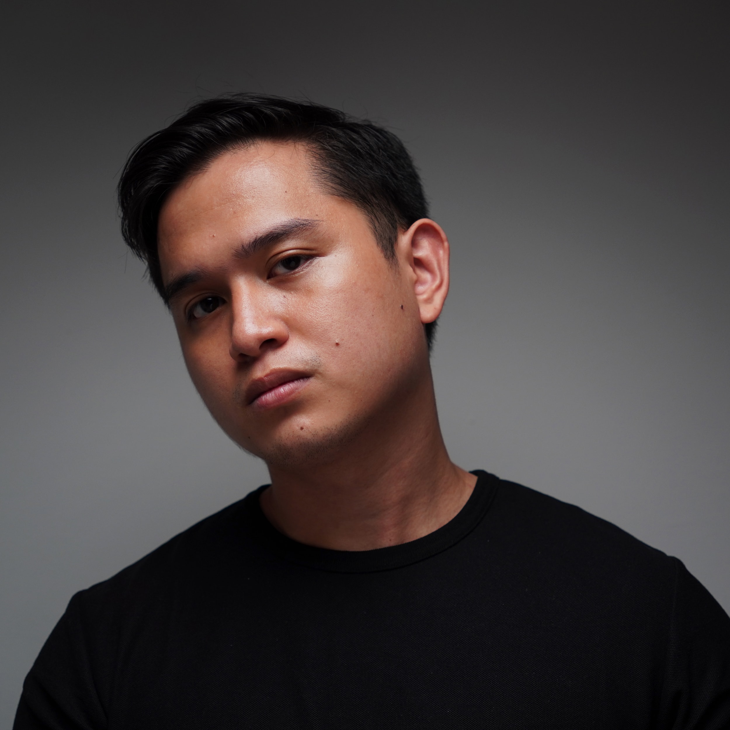 a man in a black shirt is posing for a picture
