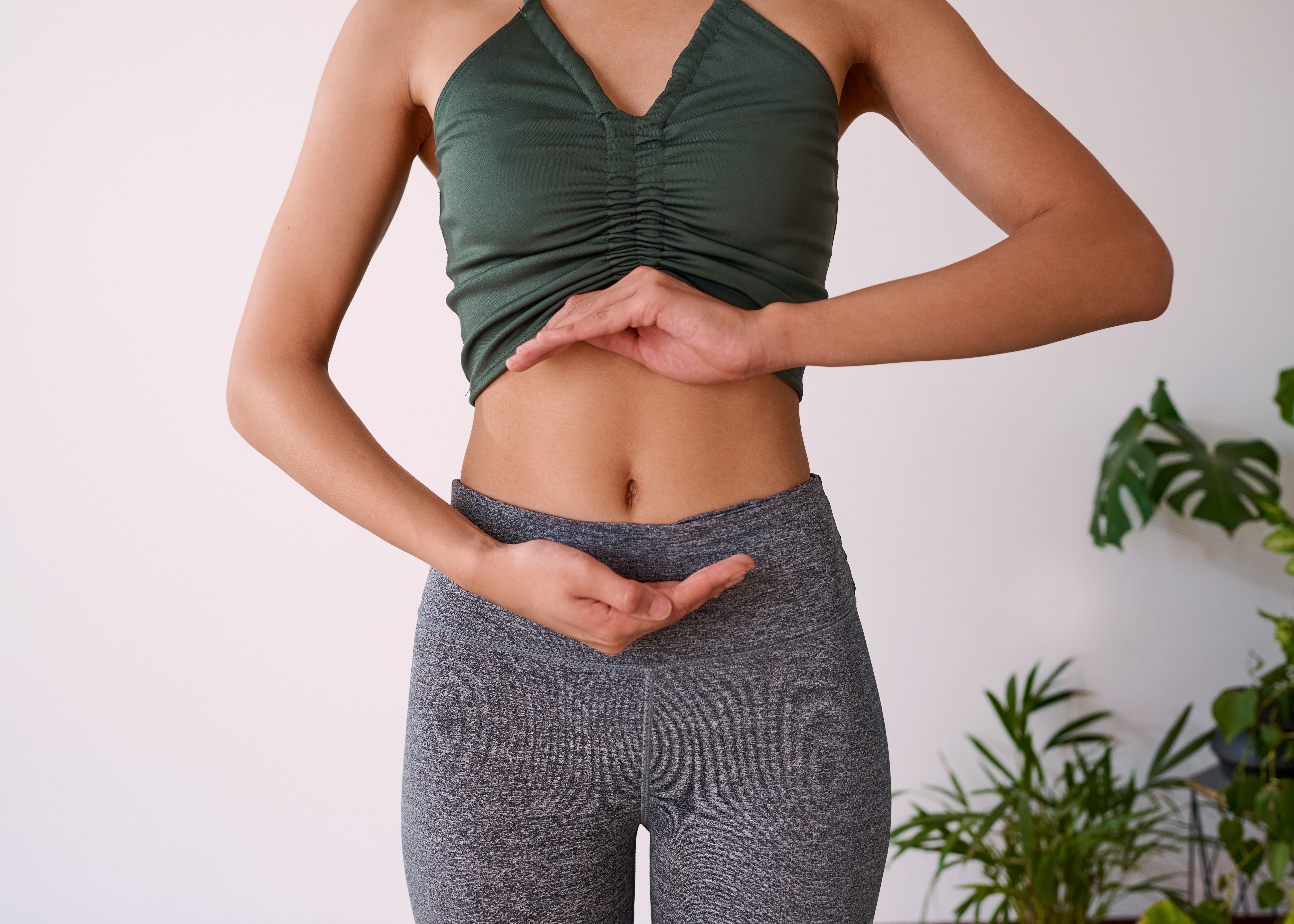 A lady holding her hands around her gut