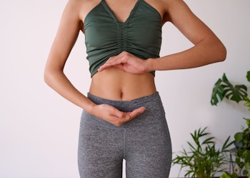 A lady holding her hands around her gut