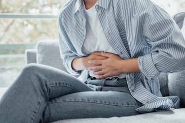 A person clutching their stomach to indicate discomfort in their gut
