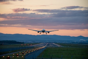 A commercial aeroplane landing at sunset, symbolising frequent travel and the importance of maintaining health, energy and wellbeing on the move.