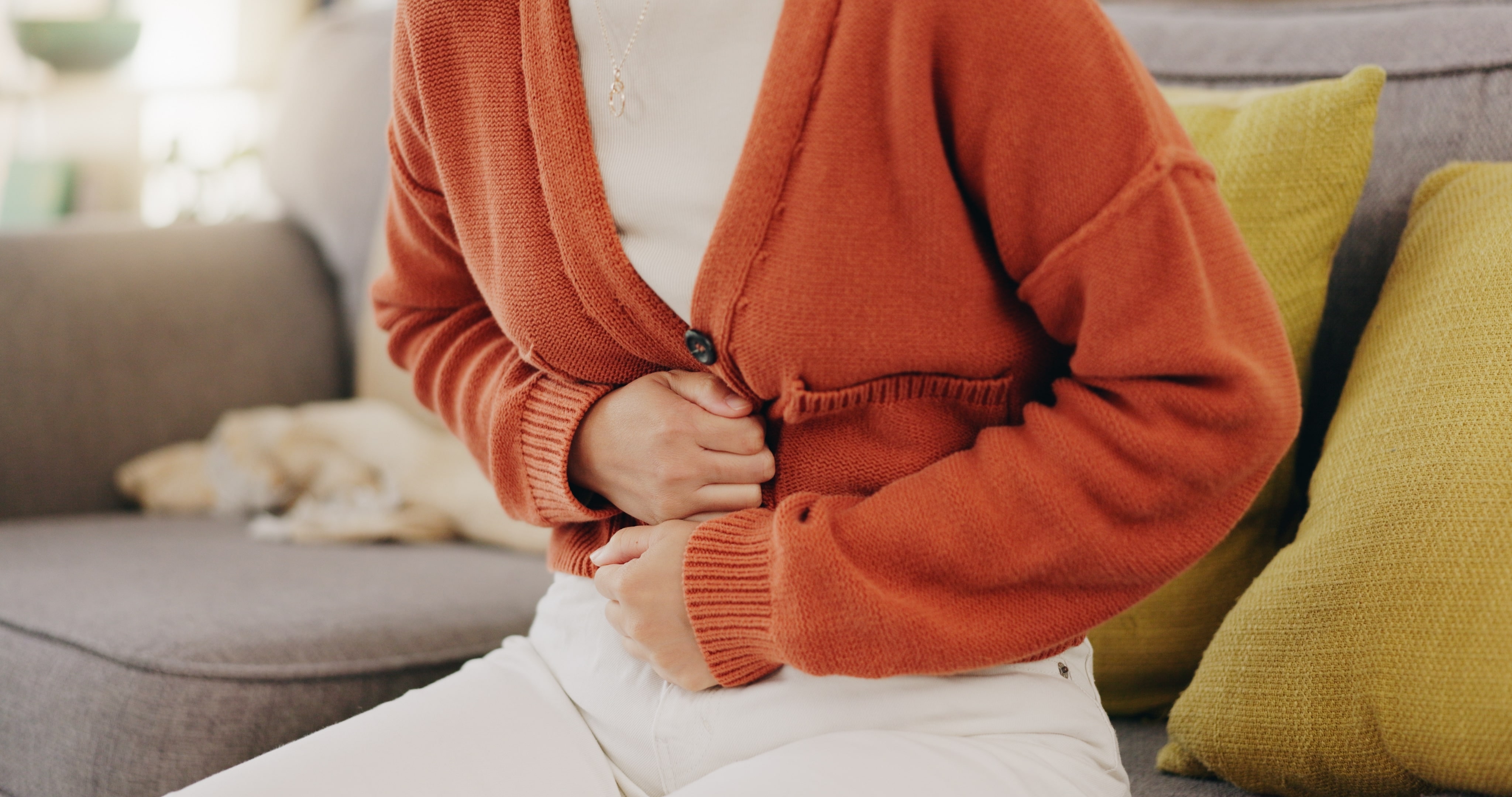 A person clutching their stomach to indicate discomfort in their gut