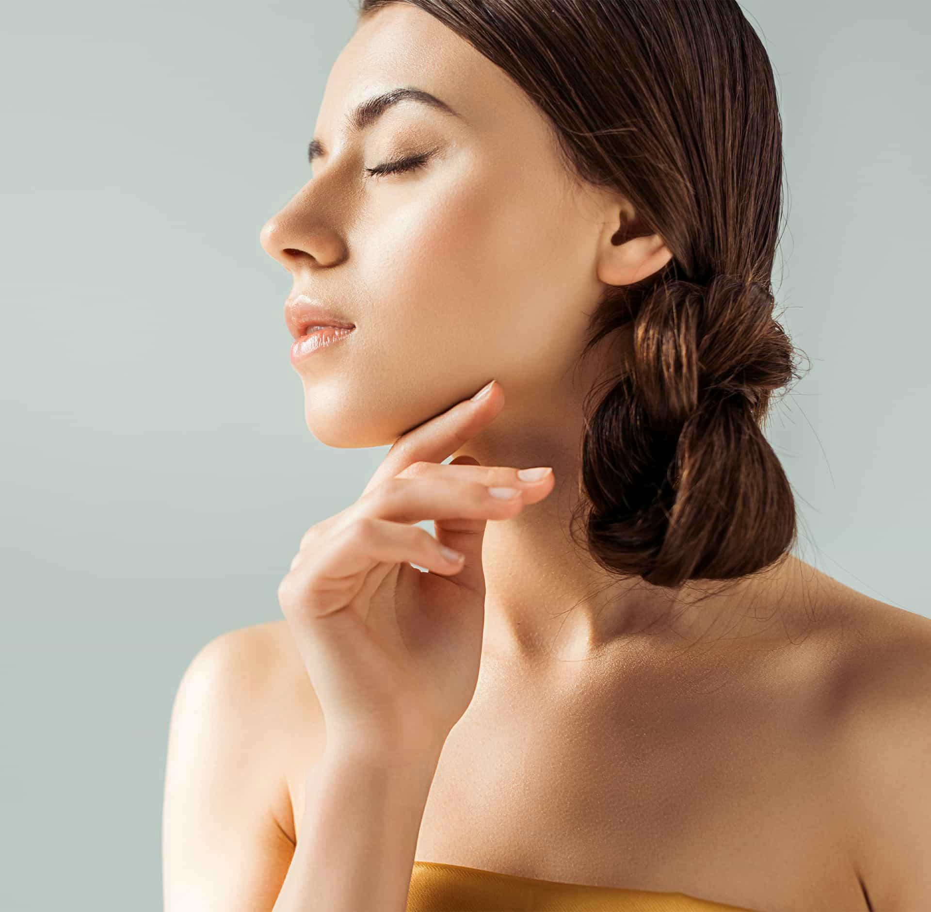 Woman closing eyes touching face