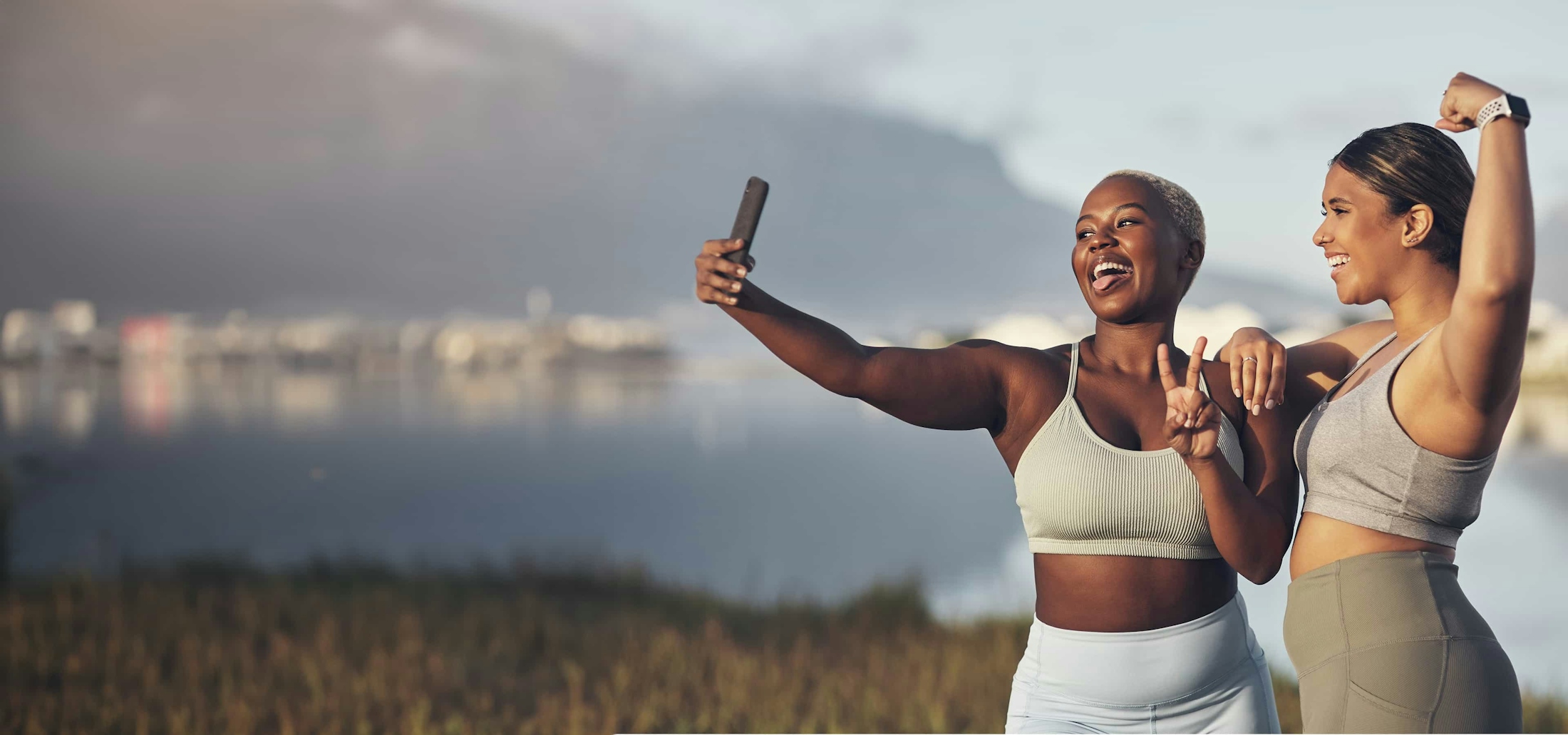 two women taking selfies on a mountain