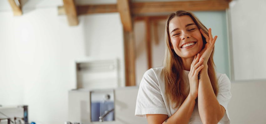 Woman smiling with hands on face