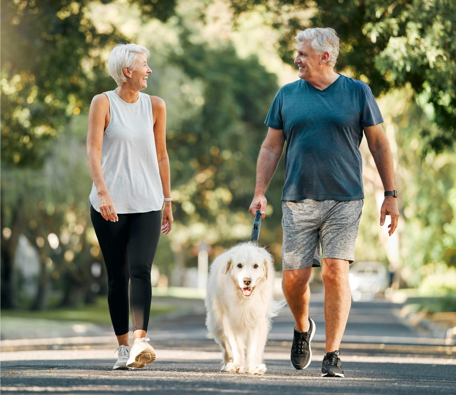 Man and woman walking a dog