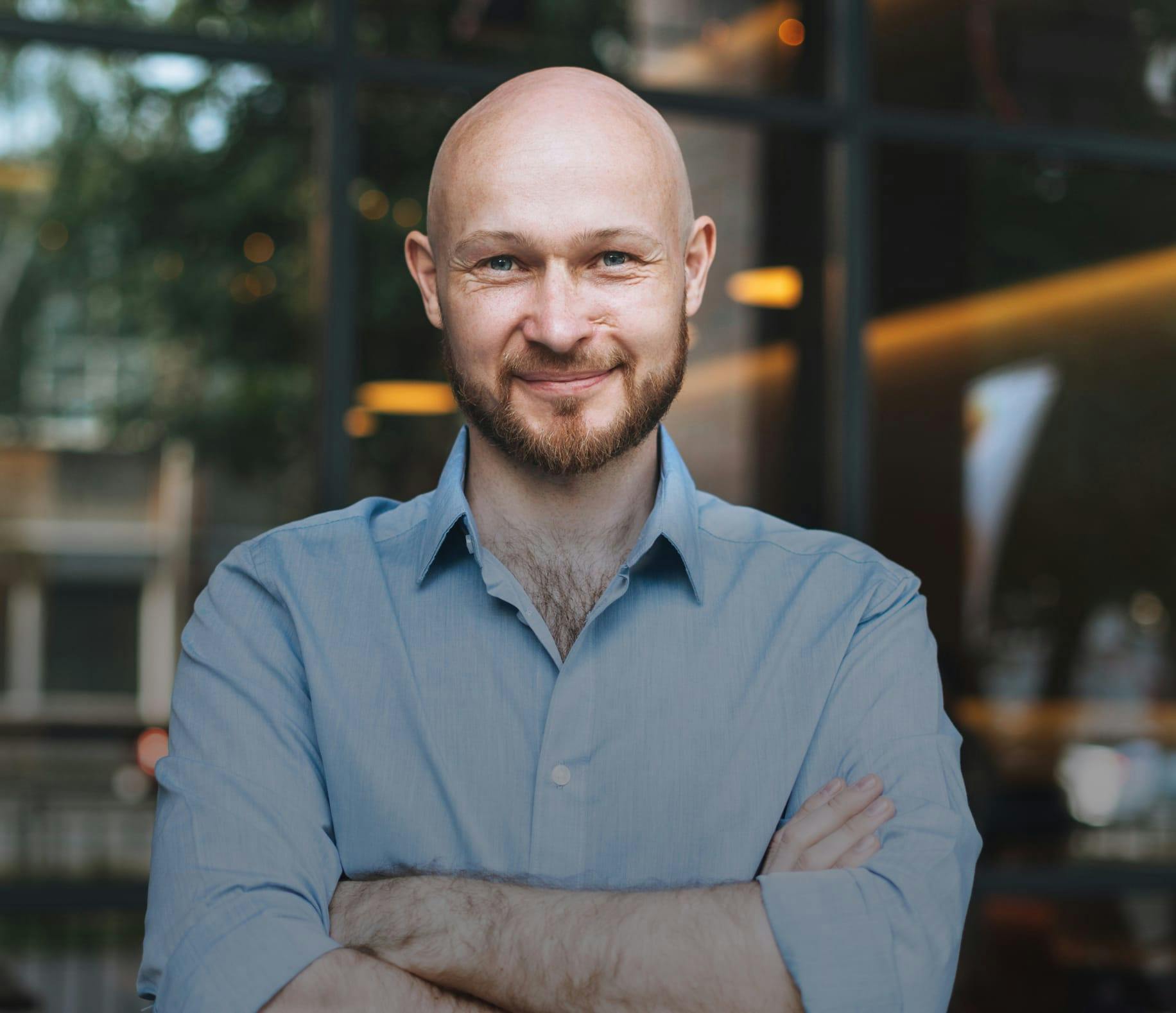 Man with his arms crossed, smiling