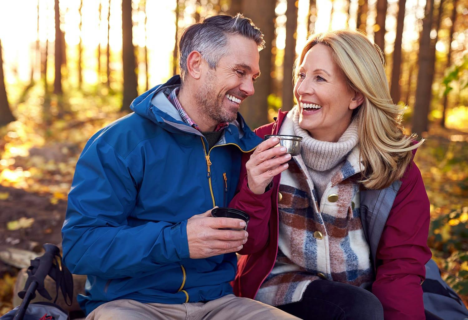 Man and woman drinking coffee in the woods