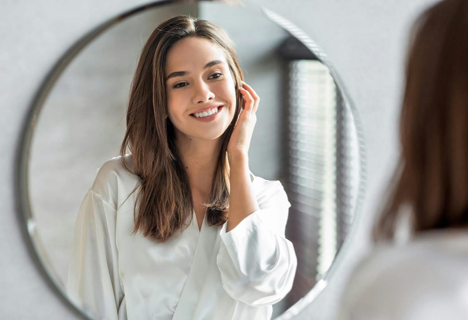 Woman smiling at herself in the mirror