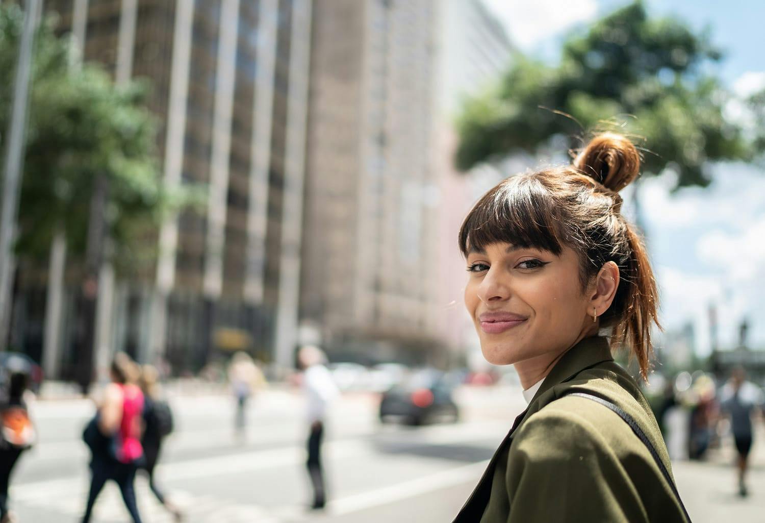 Woman smiling while standing on the sidewalk