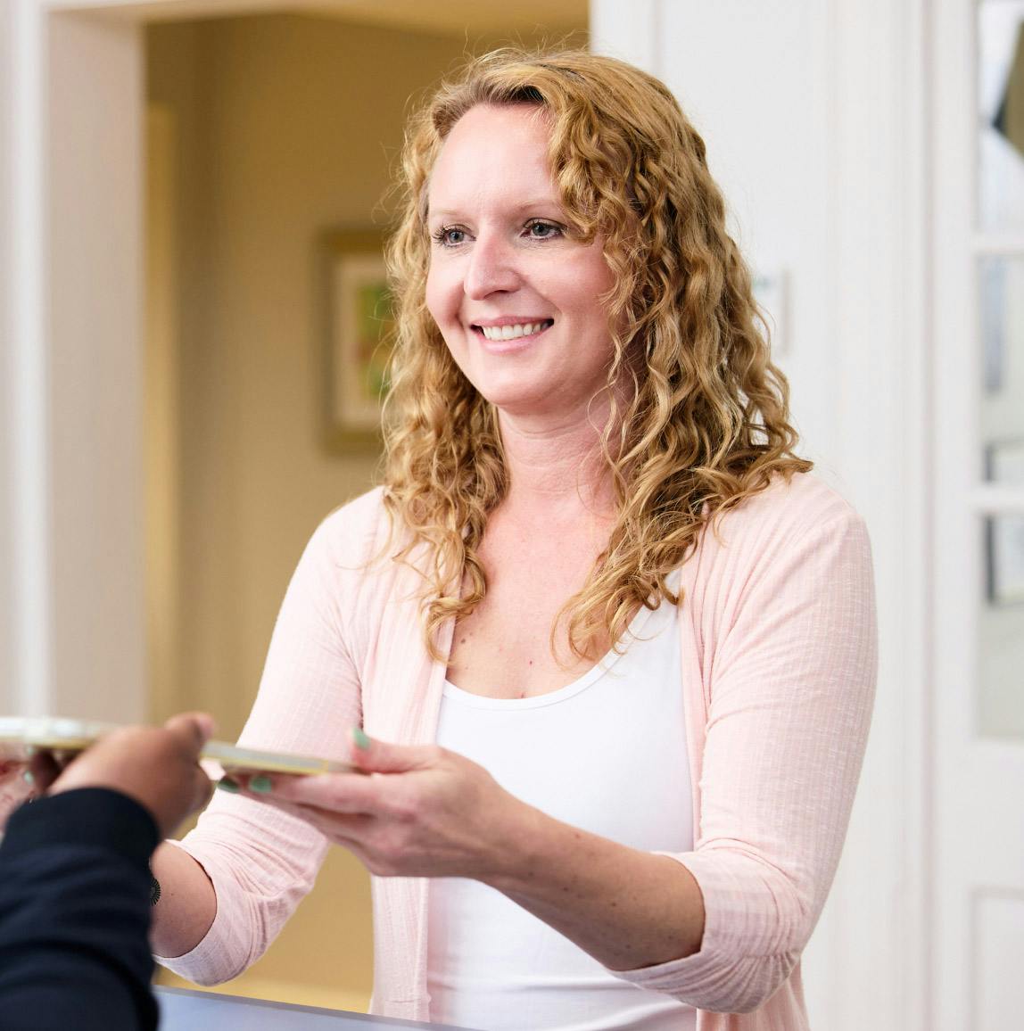 woman handing a receptionist an ipad