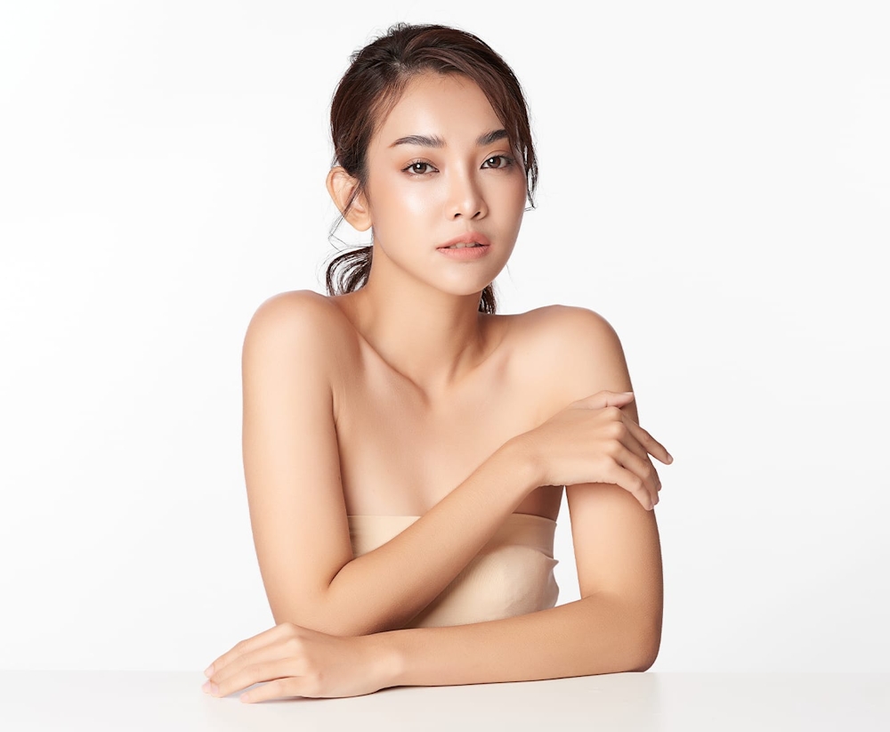 woman leaning on table with hand touching her fore arm