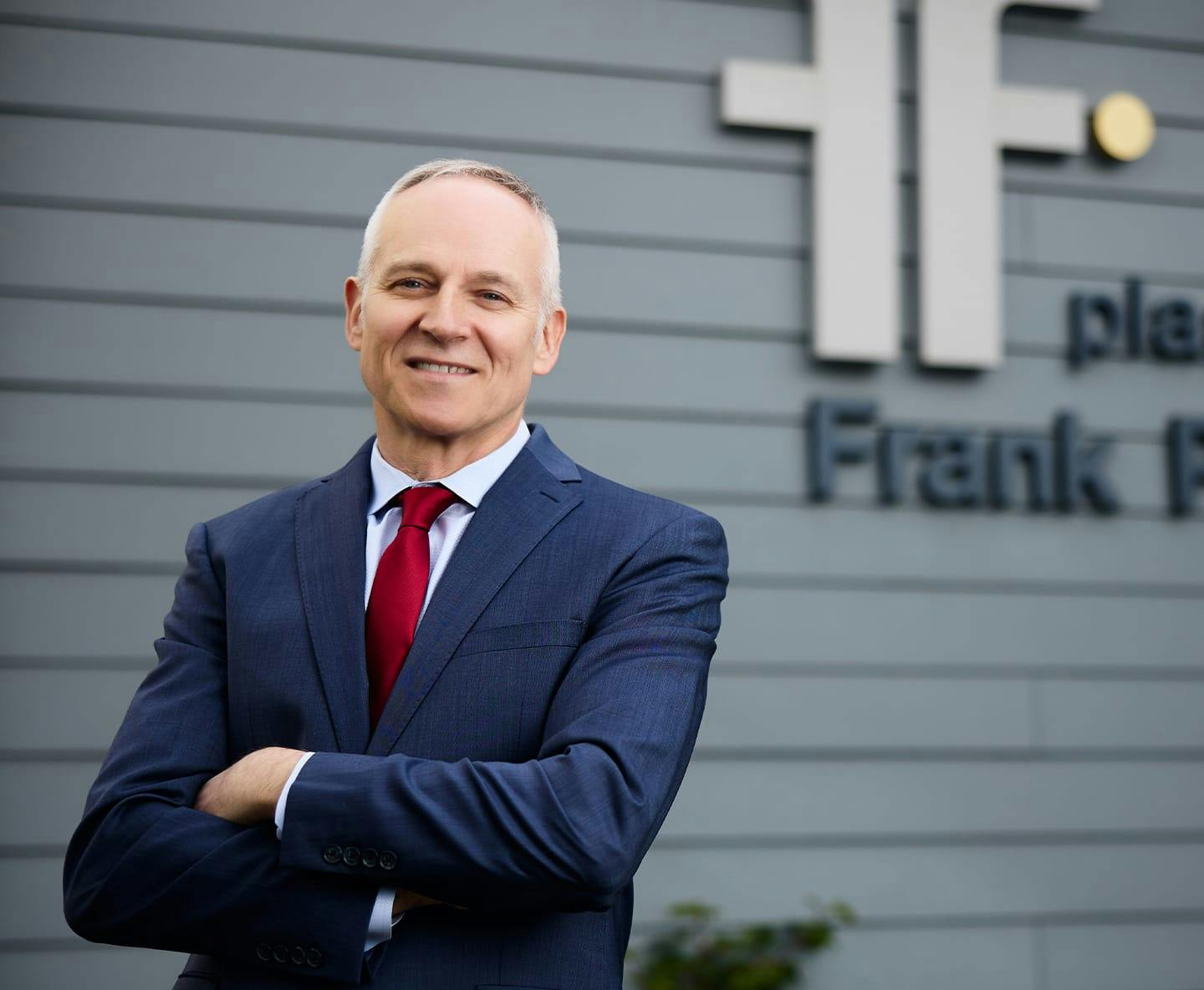 Dr. Fechner standing infront of logo