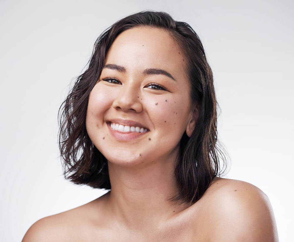 woman with freckles and short brown hair smiling