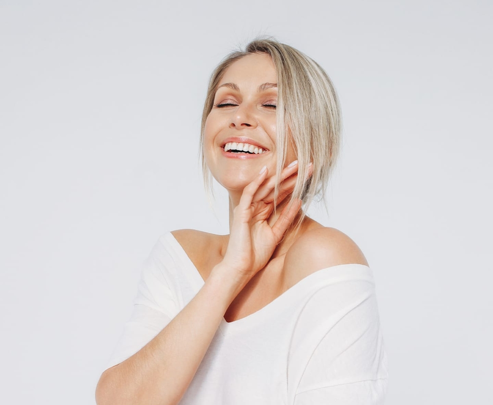woman with blonde hair looking up and smiling