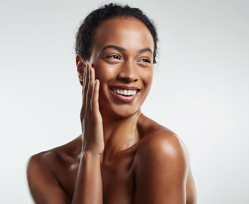 african american woman smiling with hand touching her face
