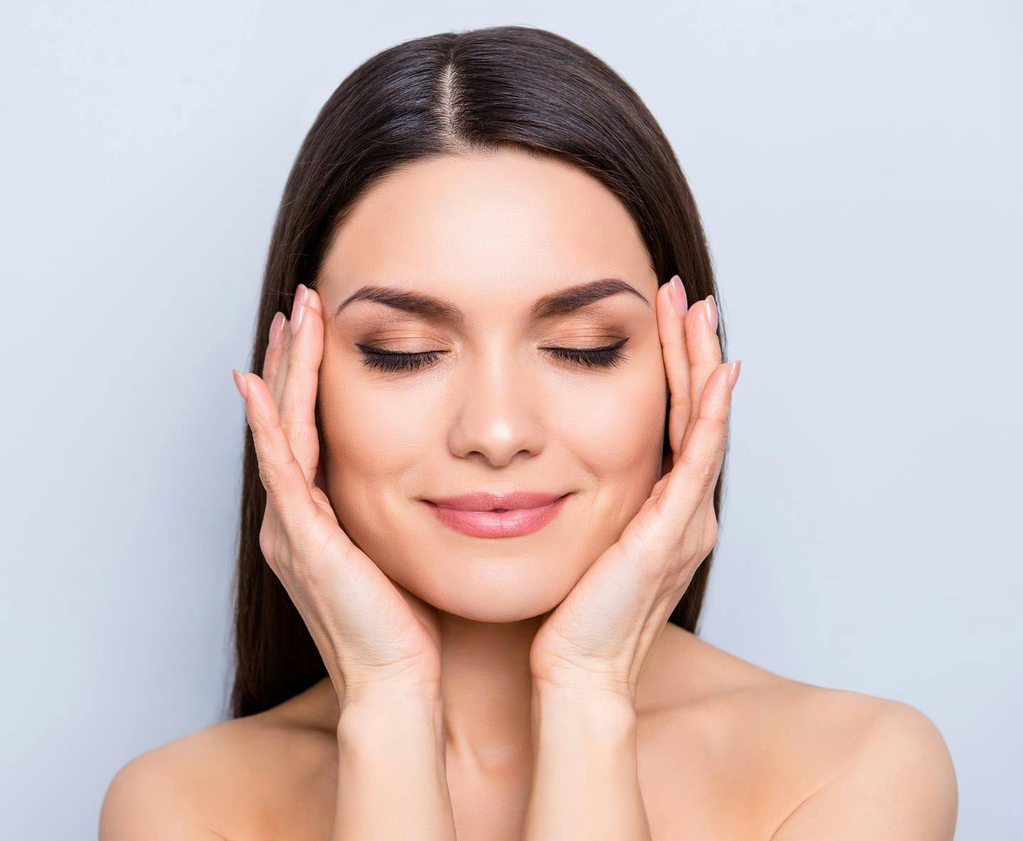 woman cupping her face with her hands while her eyes are closed