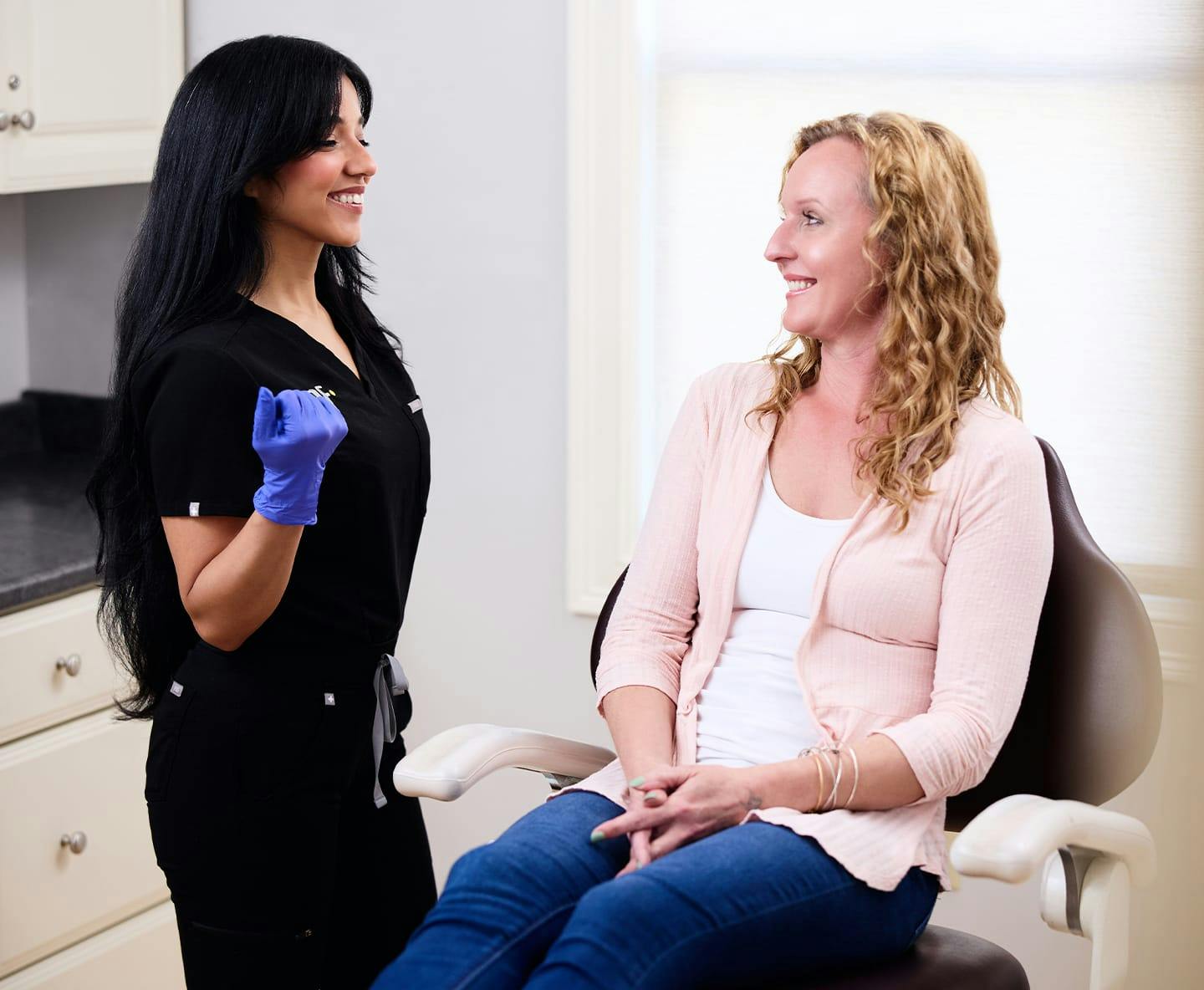 female patient sitting in chair with nurse in front of her