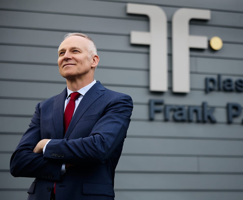 Dr. Fechner in suit in front of medspa logo