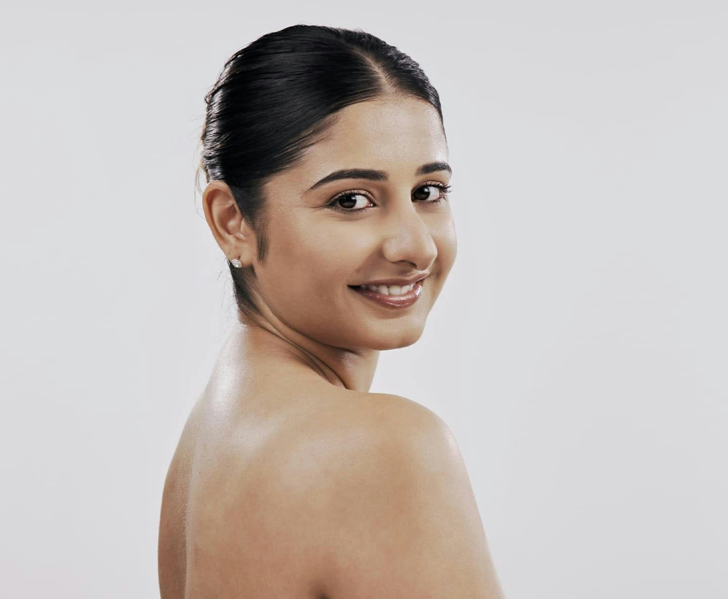 woman with hair tied up looking over her shoulder