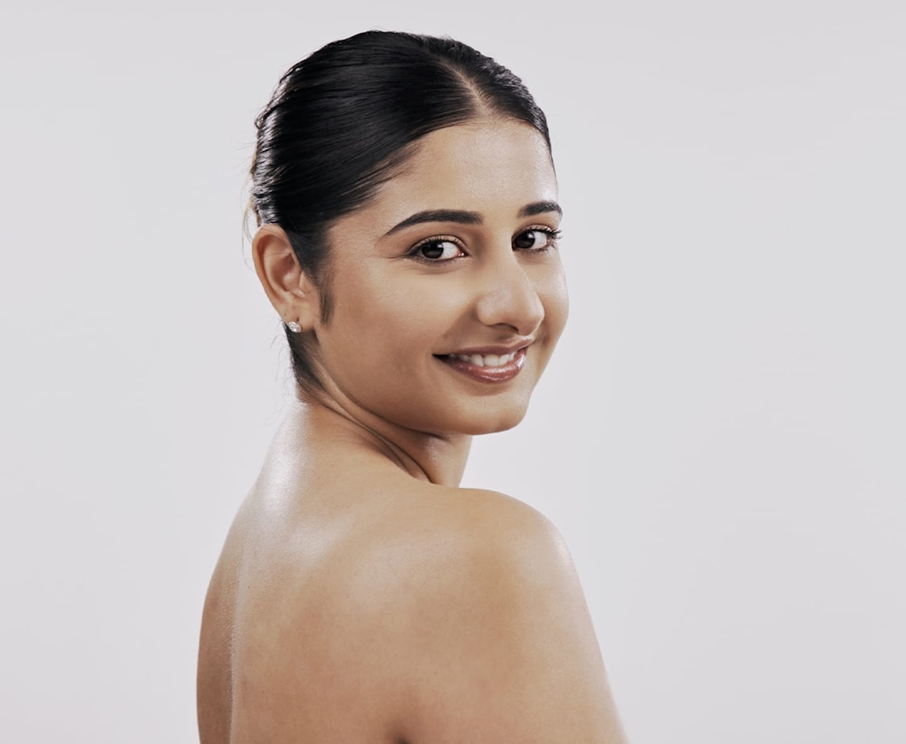 woman with hair tied up looking over her shoulder