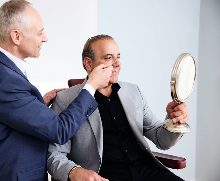 Dr. Fechner pointing to male patient's nose