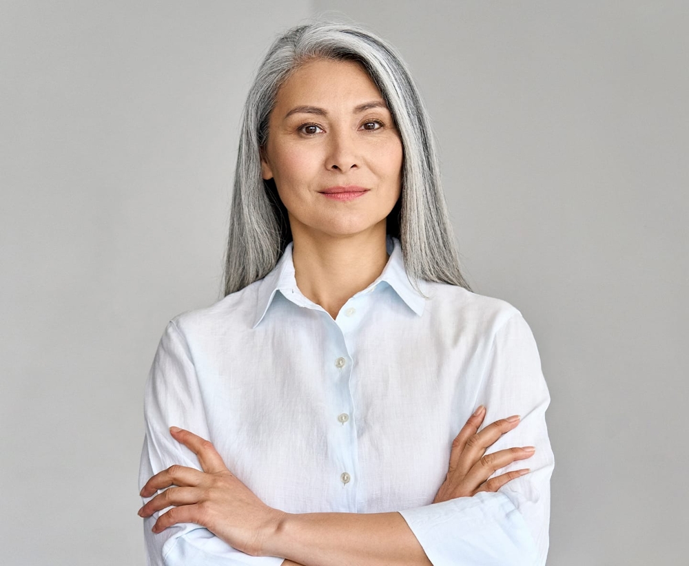older woman in white shirt crossing her arms