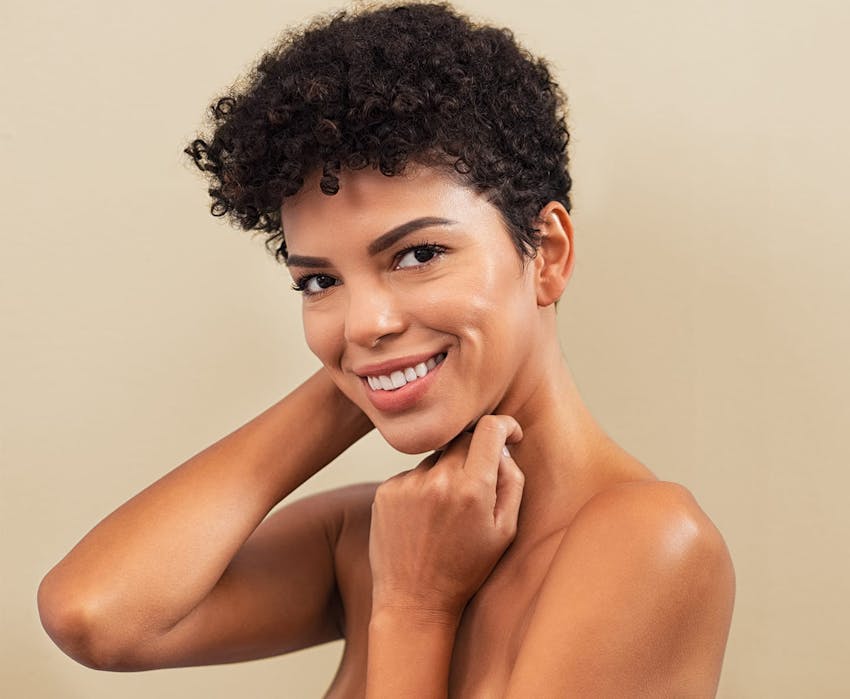 middle eastern woman with short curly hair smiling