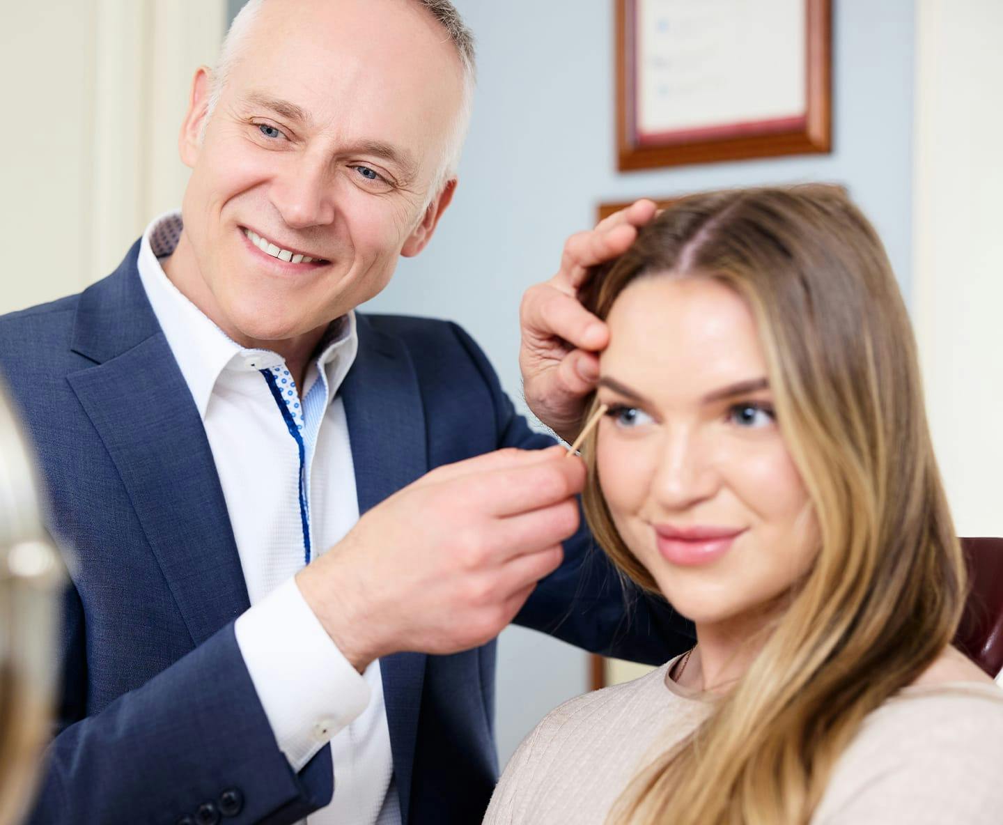 Dr. Fechner smiling with patient pointing at her eyelids